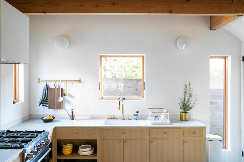 A modern and minimal kitchen with exposed wood beams.