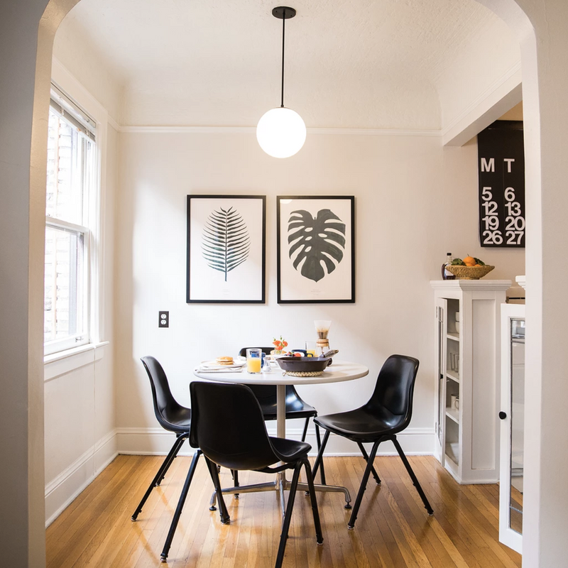 dining room with a table and black chairs and artwork