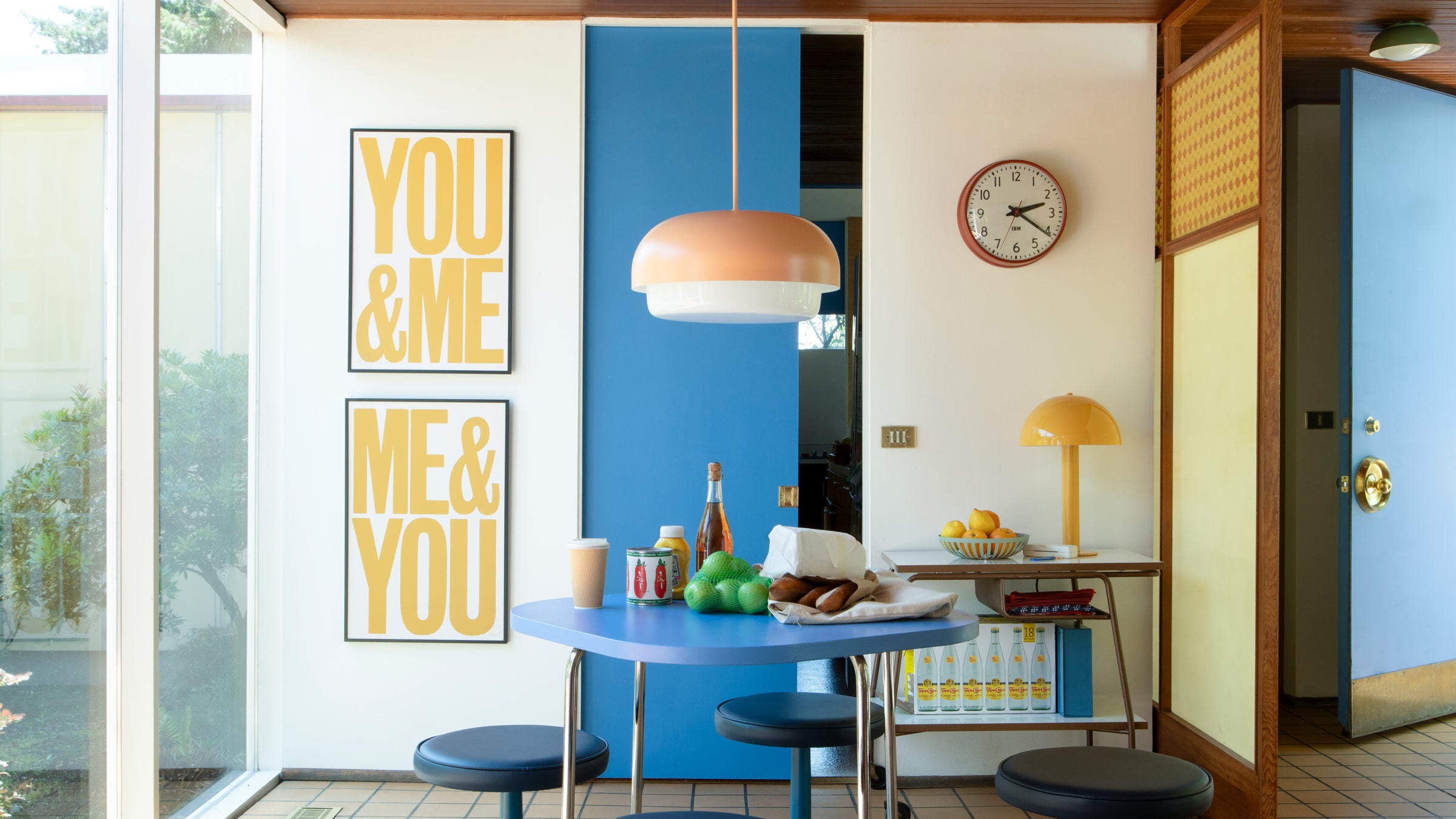 A Ray pendant in bellini pink over a dining table.
