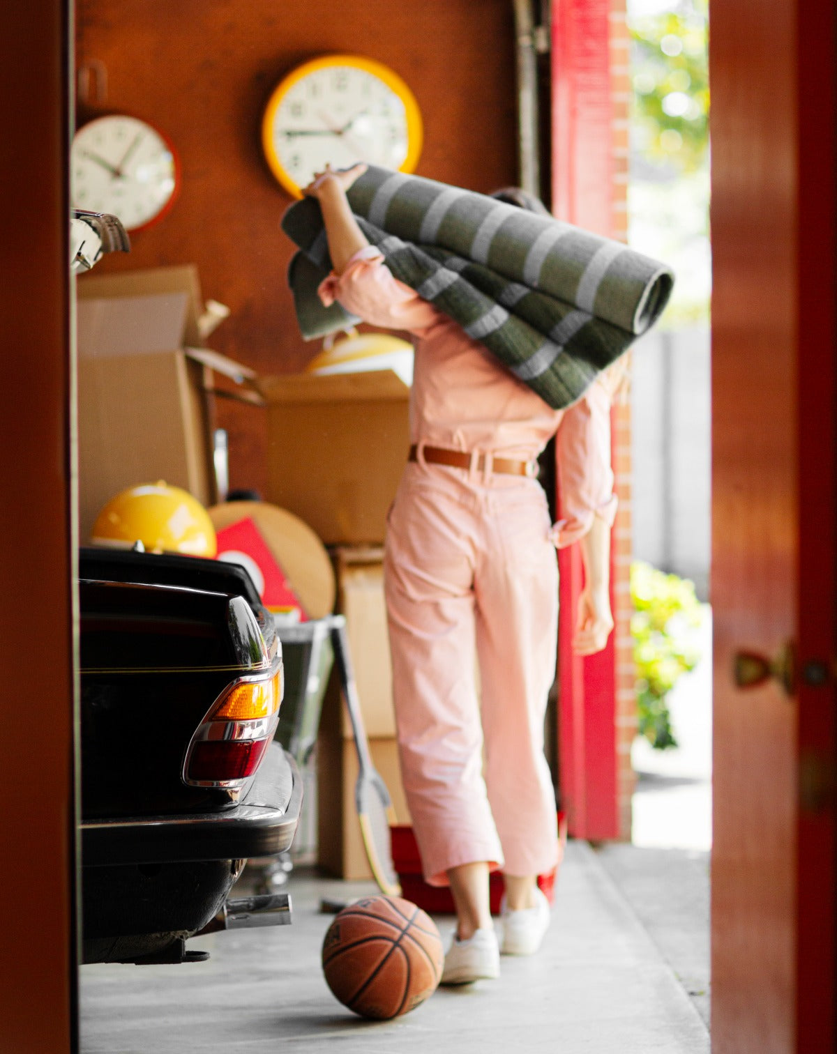 Woman holding a rolled up rug in garage