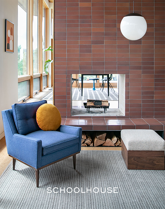 Blue chair in front of brick fireplace