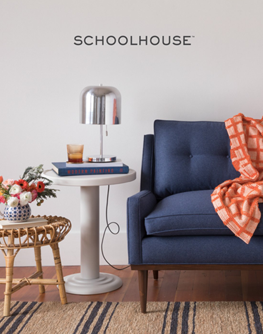 Navy blue chair next to side tables with lamp and flowers